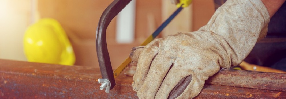 Person sägt Metall mit Bügelsäge